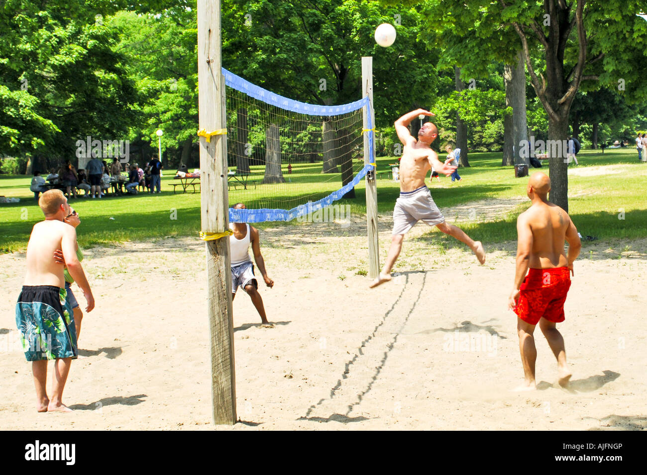 Teenage college students playing beach vollyball on their summer