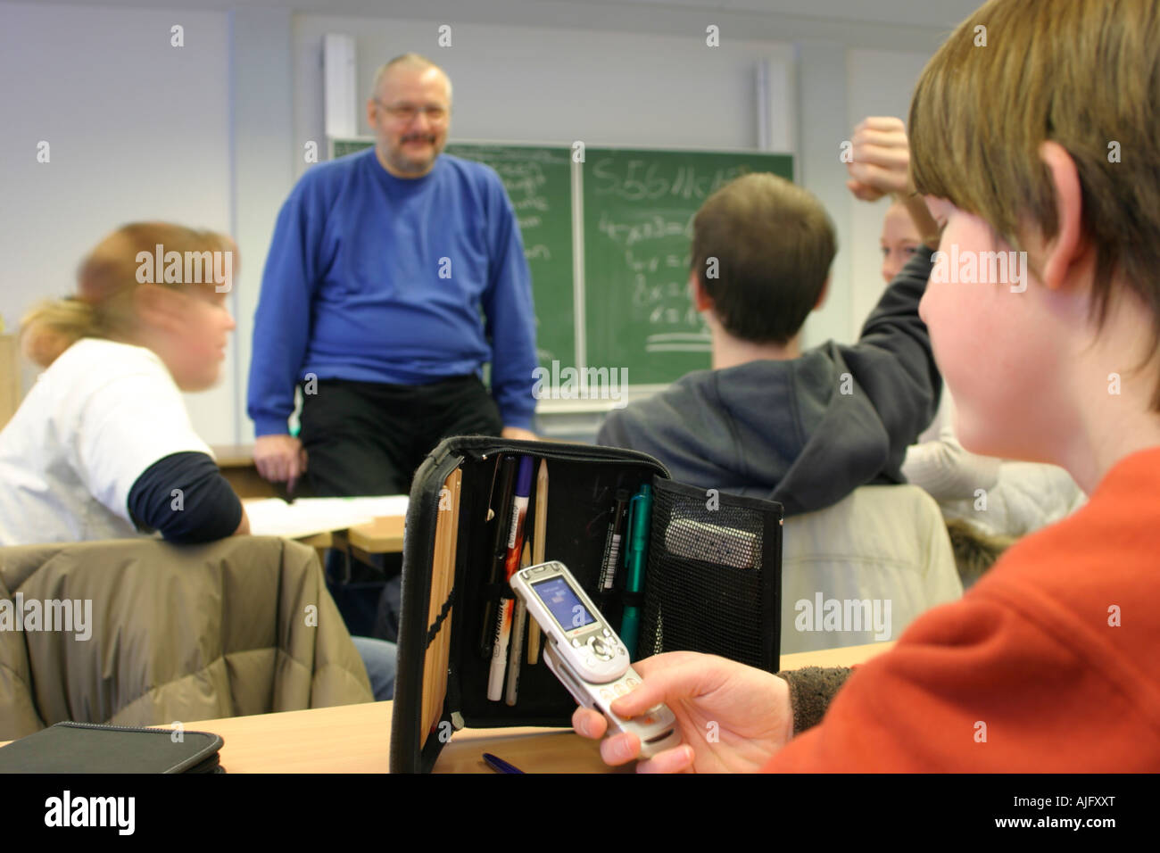 teenager playing with a mobile phone during class Stock Photo Alamy