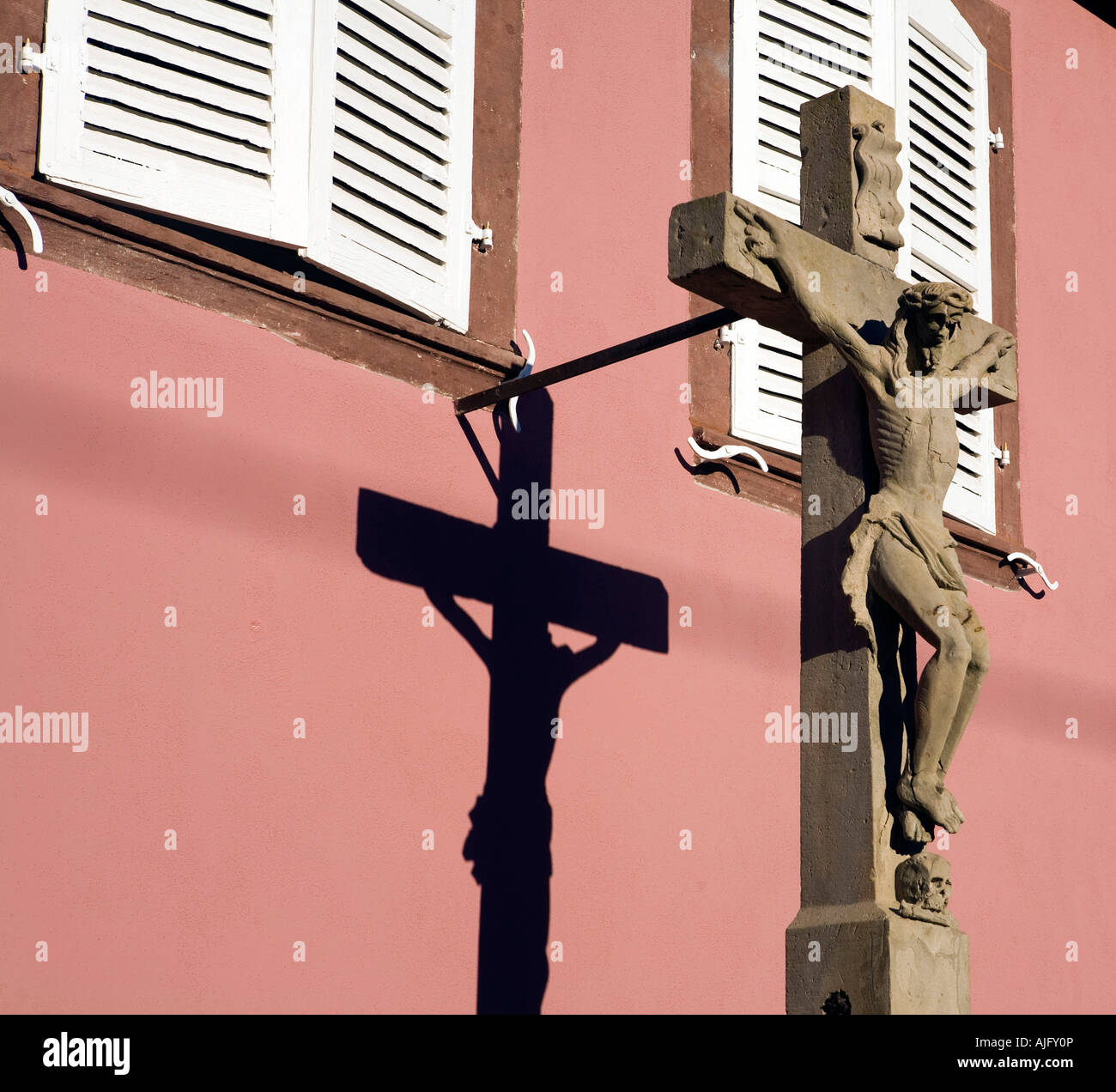 A sculpture of Jesus on the cross a common sight throughout Alsace adorns a house in Nothalten Stock Photo