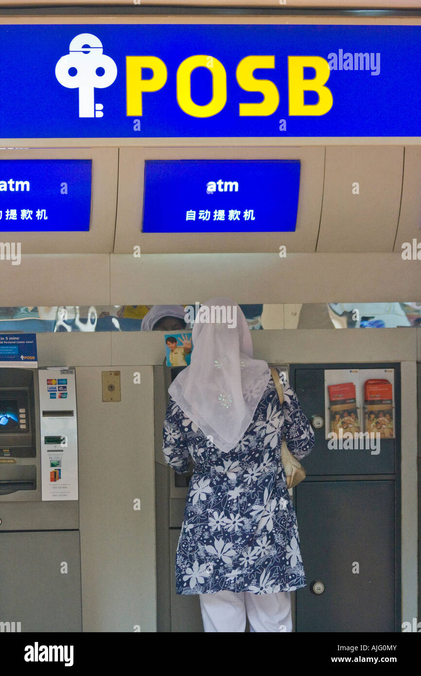 Muslim Woman Removing Money At A Posb Bank Atm Stock Photo