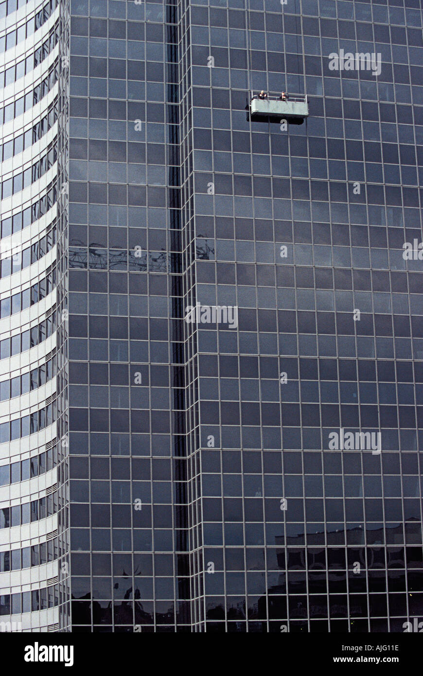 Washing windows on office tower Stock Photo