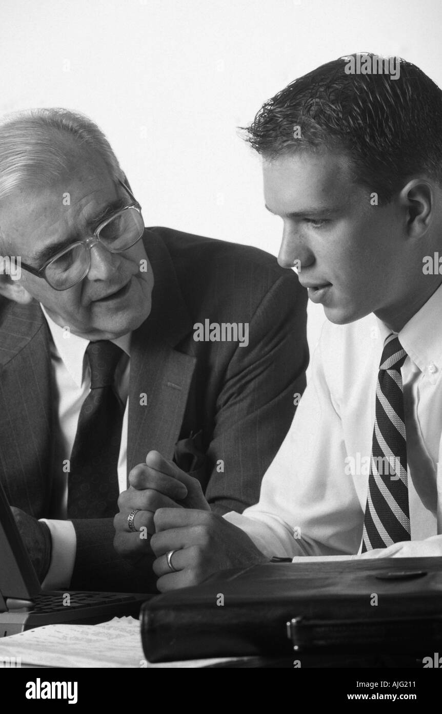 Black and white photo of an Experienced Senior executive mentoring jExperienced junior executive in a Business Meeting Stock Photo