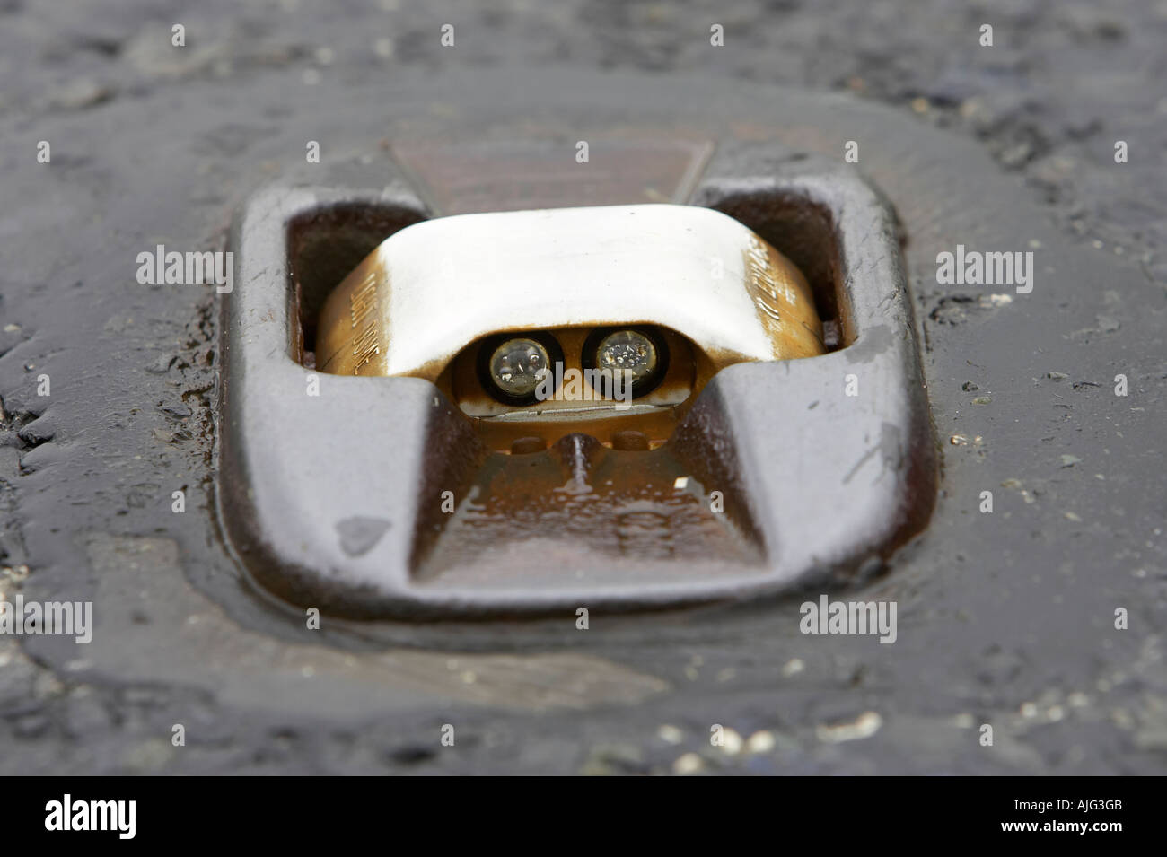 cats eye in the middle of a wet mountain road in the mourne mountains county down northern ireland Originally designed by Percy Shaw Stock Photo