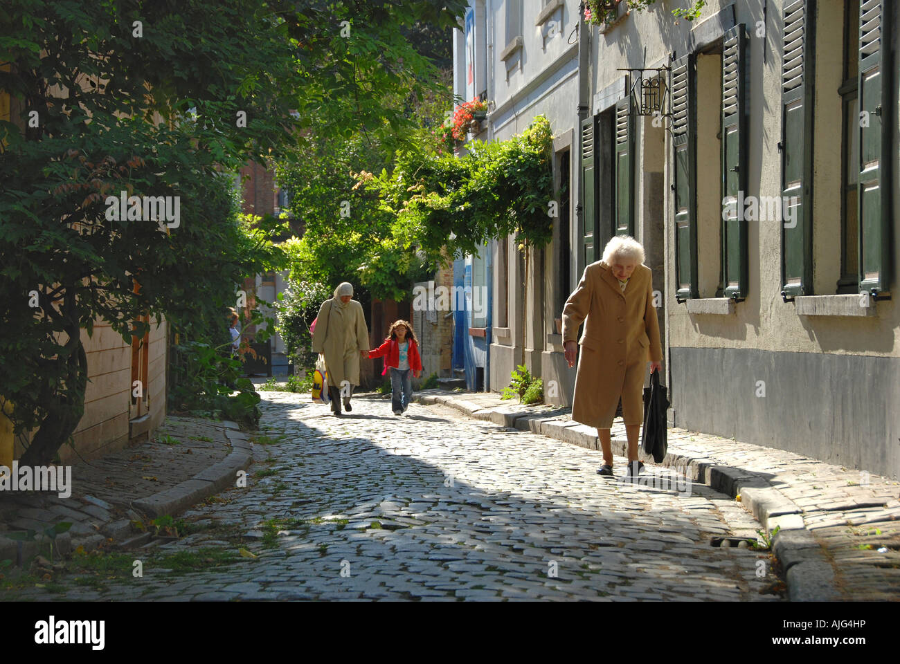 Old woman walking in a street Stock Photo