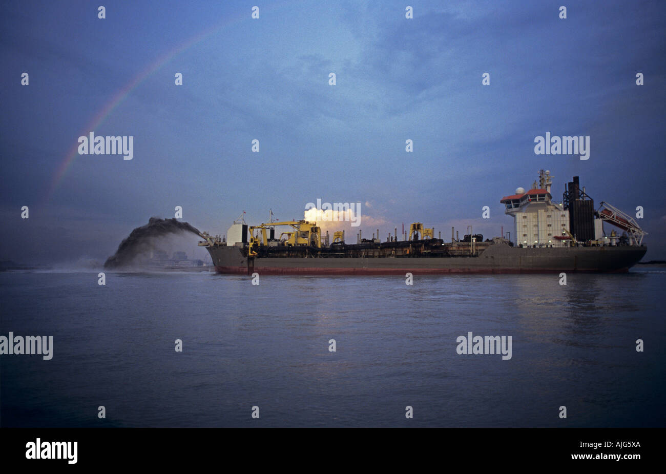 Dredger rainbowing or discharging cargo of sand for land reclamation project, Singapore Stock Photo