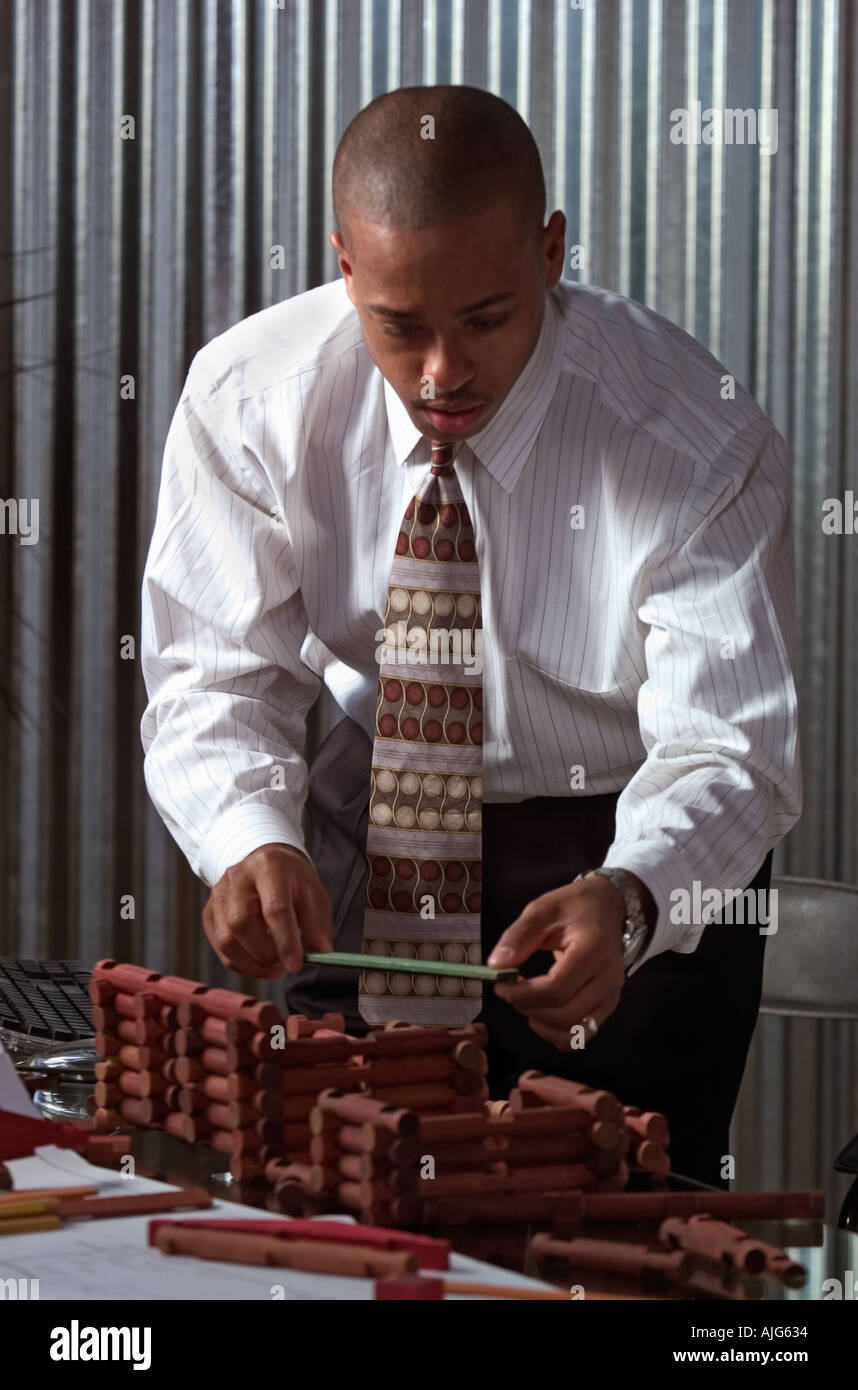 African American businessman using construction toy to explain concept to architect Stock Photo