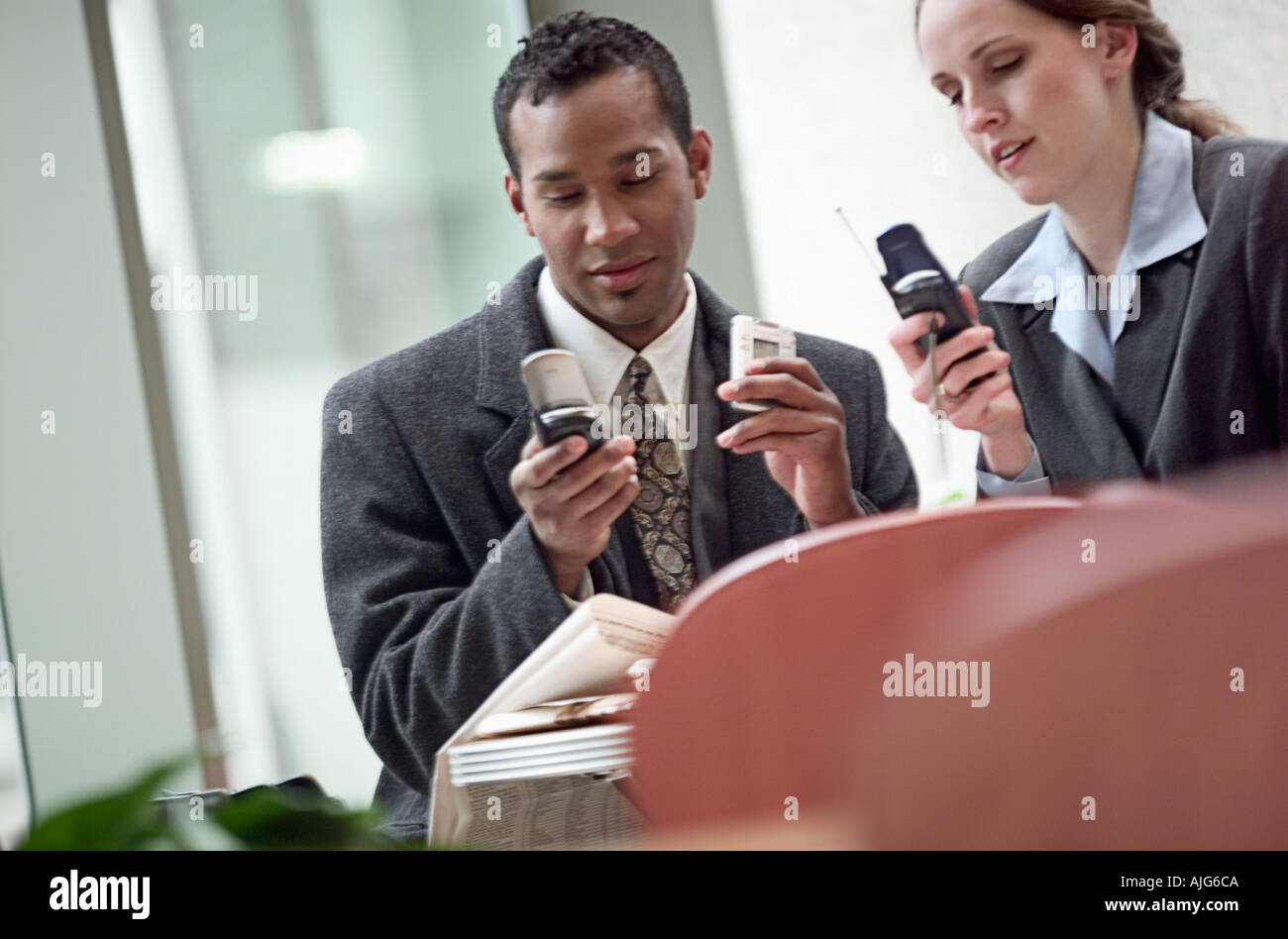 African American businessman and Caucasian businesswoman on cell phones Stock Photo