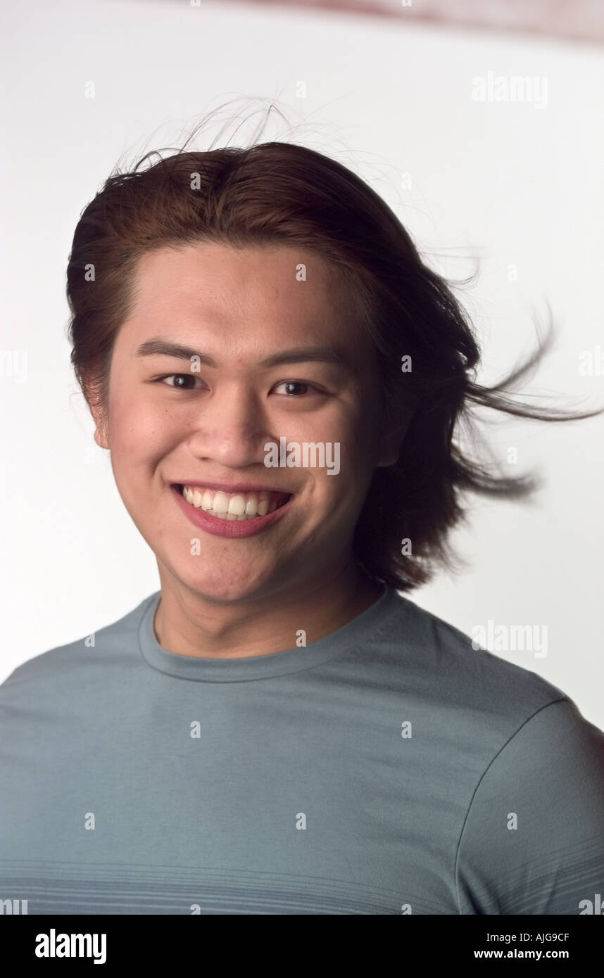 Portrait Asian man smiling with hair blowing Stock Photo