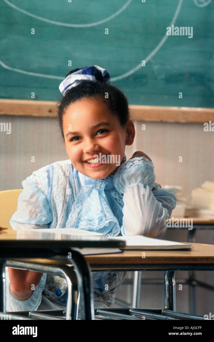 Portrait of Latino female student sitting at desk in class Stock Photo
