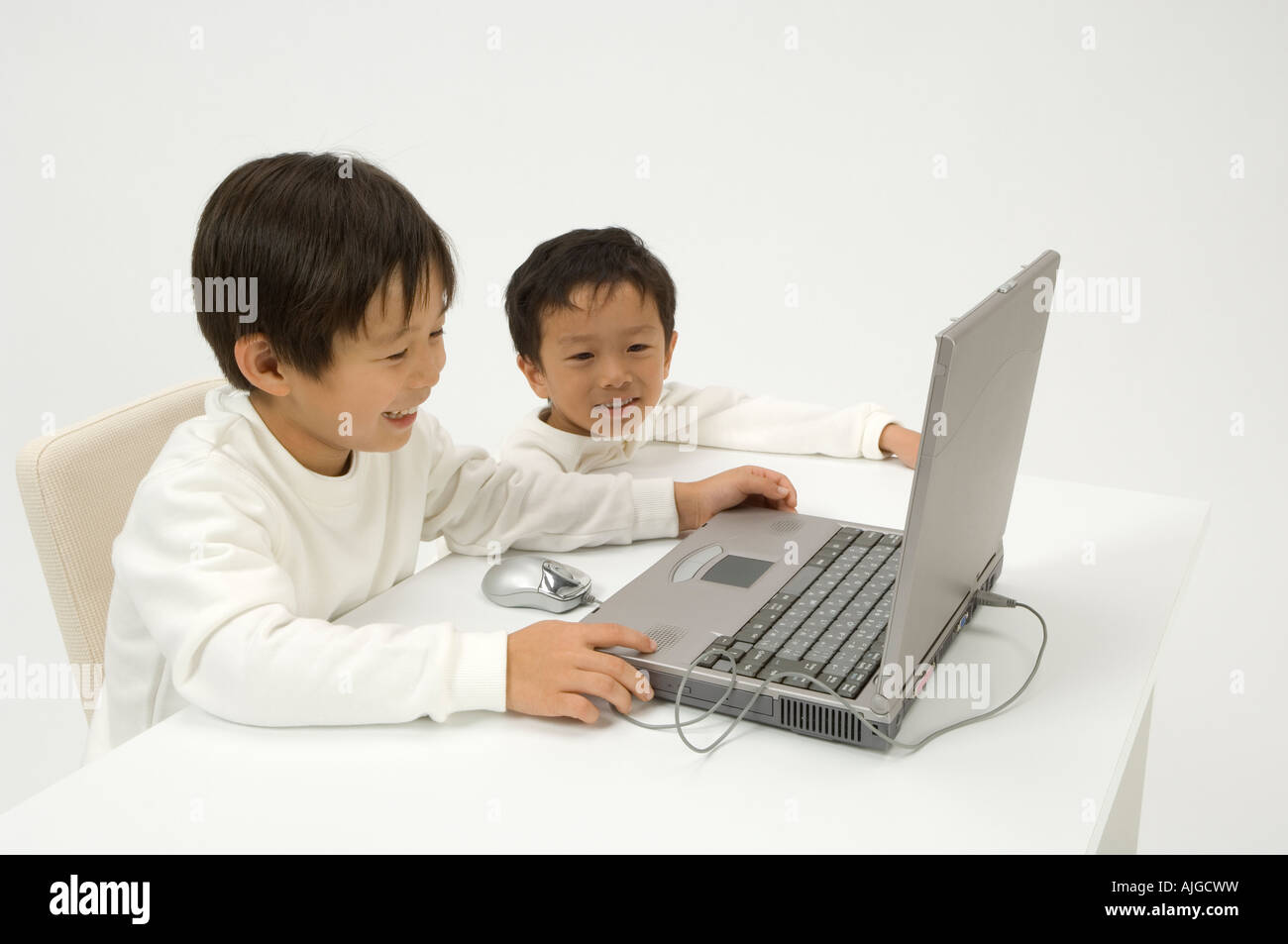Two elementary age boys using laptop Stock Photo - Alamy