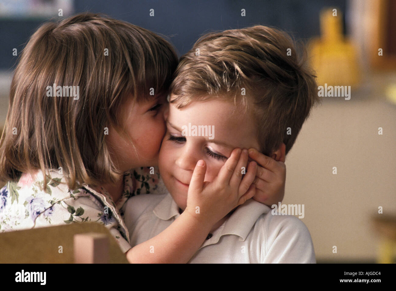 Caucasian preschool female student kissing male in class Stock Photo