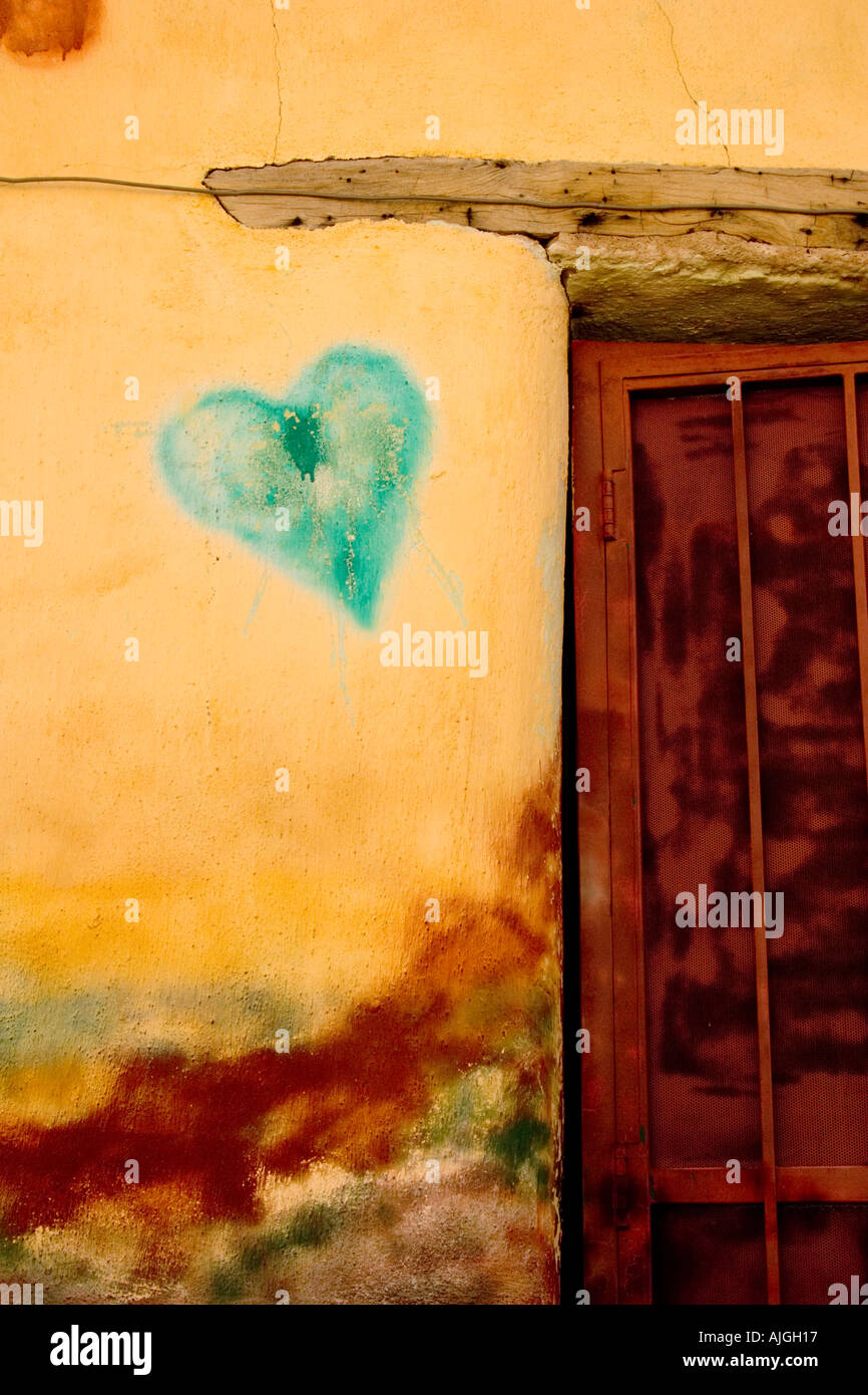 Green heart painted on an adobe wall in Tucson s barrio district Stock Photo