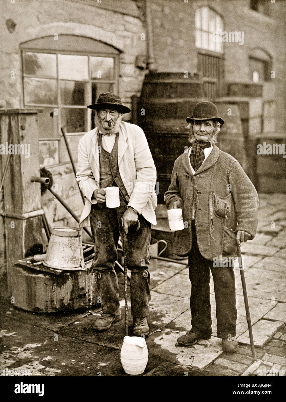 Bidford Topers, A couple of of drinkers in Bidford on Avon photographed by Benjamin Stone at the village pump, mugs in hand Stock Photo