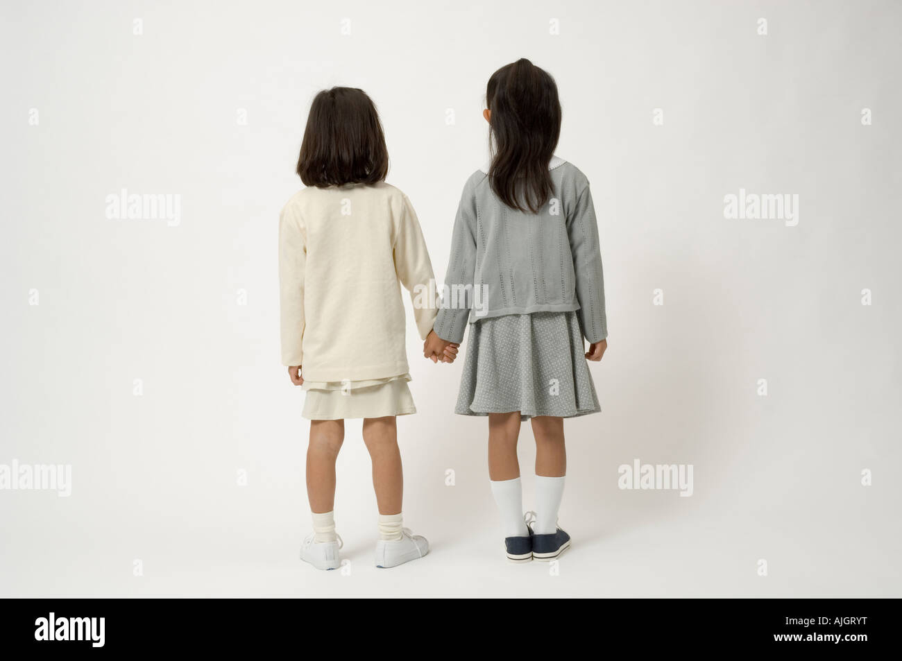 Two elementary age girls standing, rear view Stock Photo