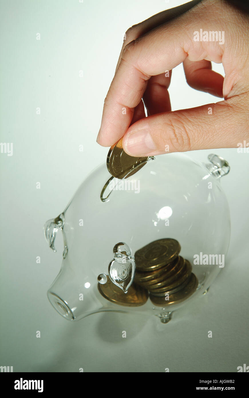 High angle view of a man s hand putting coins into a piggy bank Stock ...