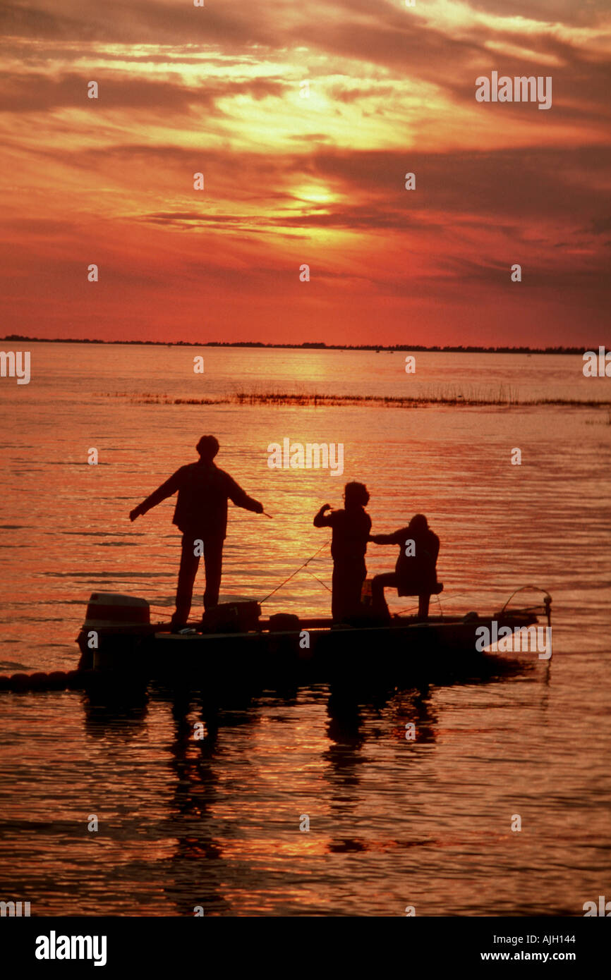 Family bass fishes on Lake Okeechobee Florida against a sunset Stock Photo