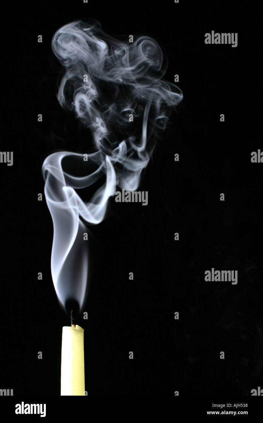 Candle smoking with smoke forming the shape of a face Stock Photo