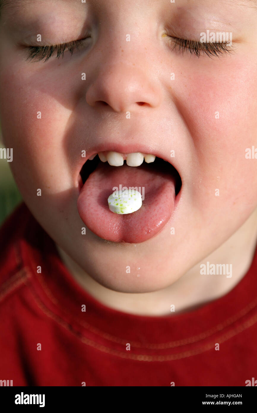 Tablet on Tongue of Little Boy Child Taking a Pill with his mouth wide