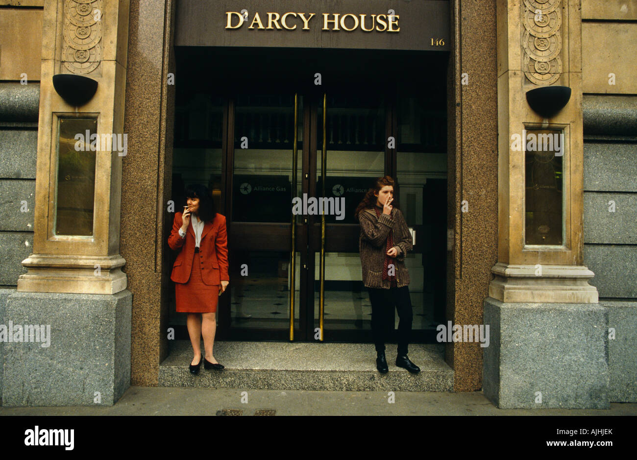 Women office workers in their 30s take a cigarette break outside their place of work s steps in the City of London Stock Photo