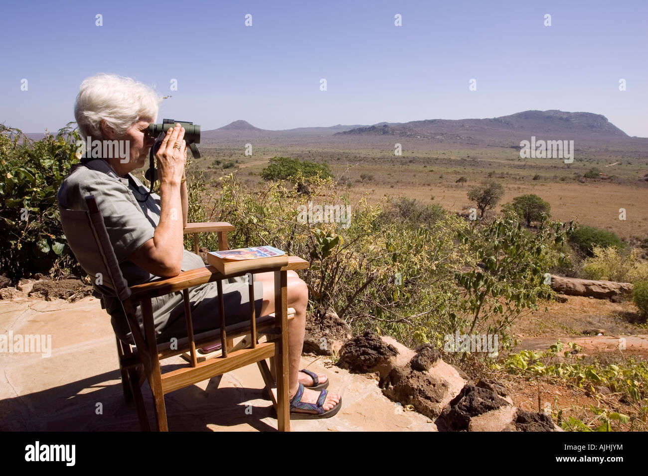 Tourist bird watching from veranda at Ngulia Bandas in Tsavo National Park West Kenya East Africa Stock Photo