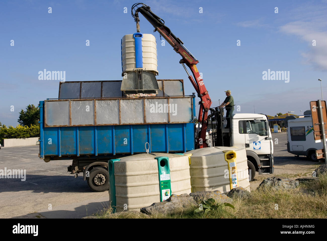Lorry with hoist emptying plastic paper recycling bin Normandy France