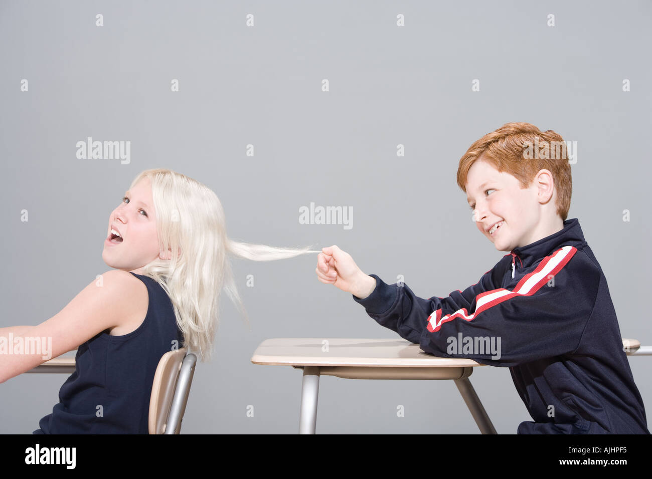 Boy pulling girl's hair Stock Photo - Alamy