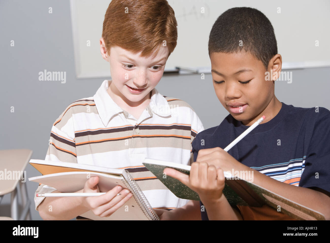 Boys writing in notebooks Stock Photo