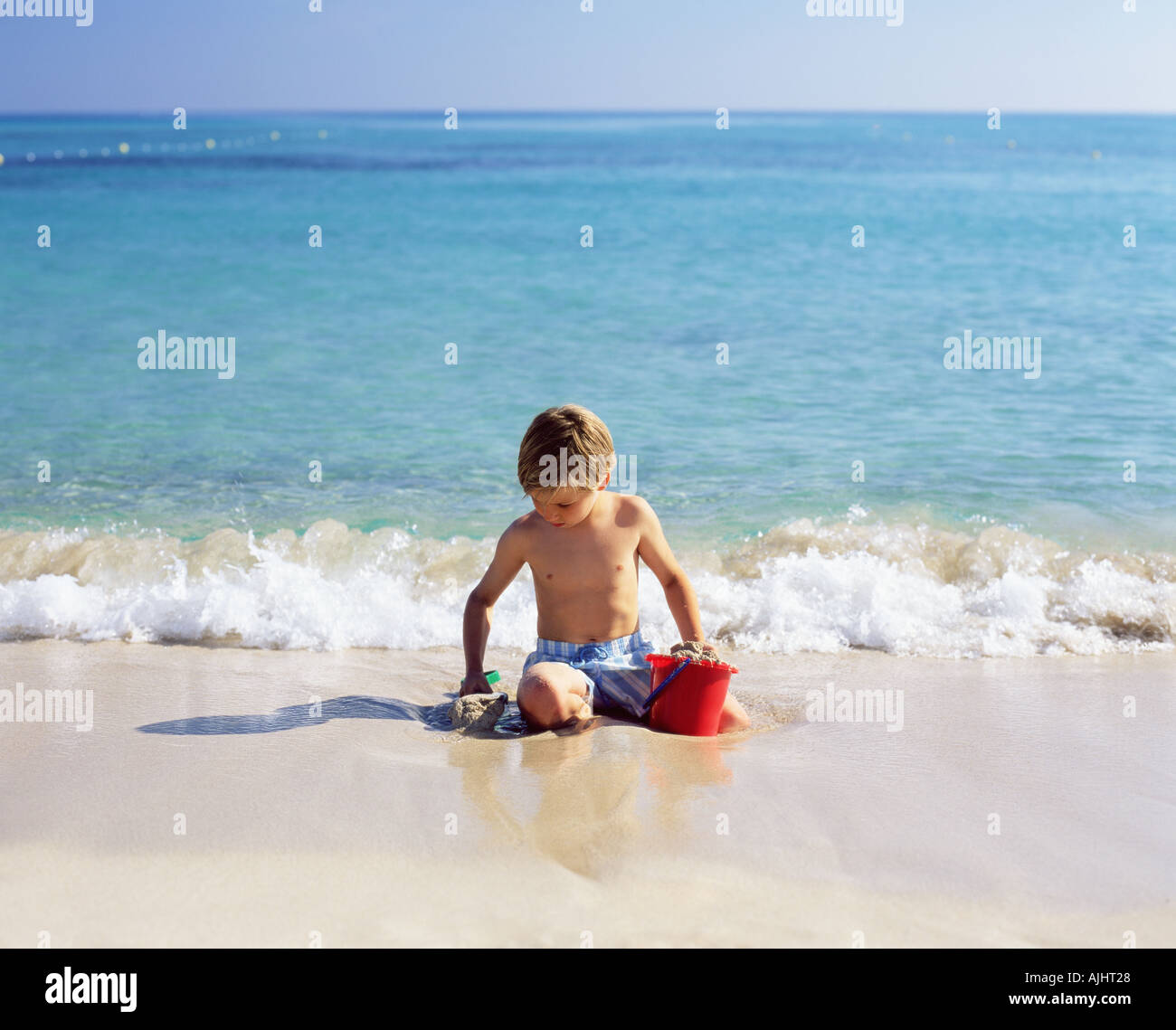 Boy playing with wet sand Stock Photo