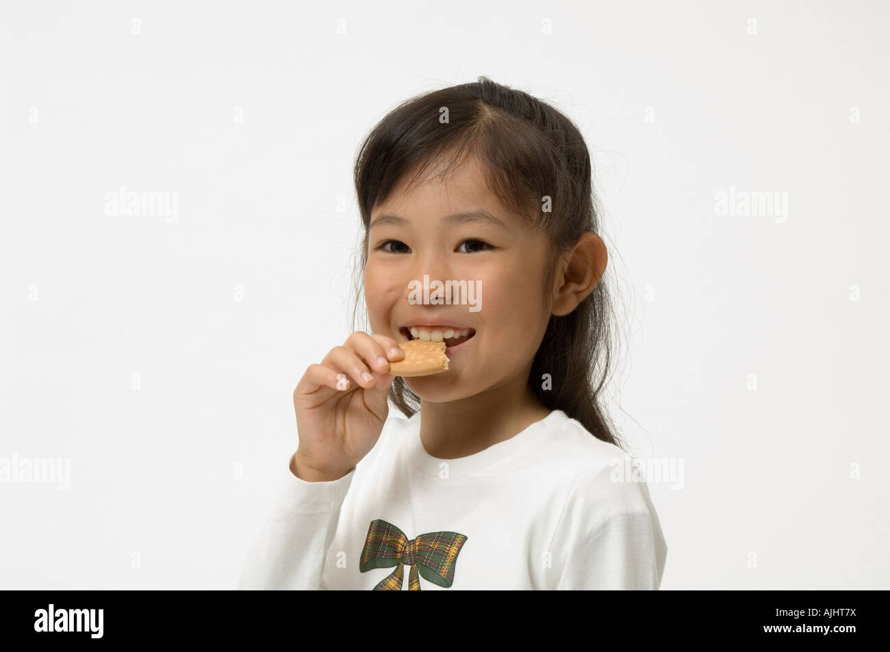 Elementary age girl eating cookie Stock Photo