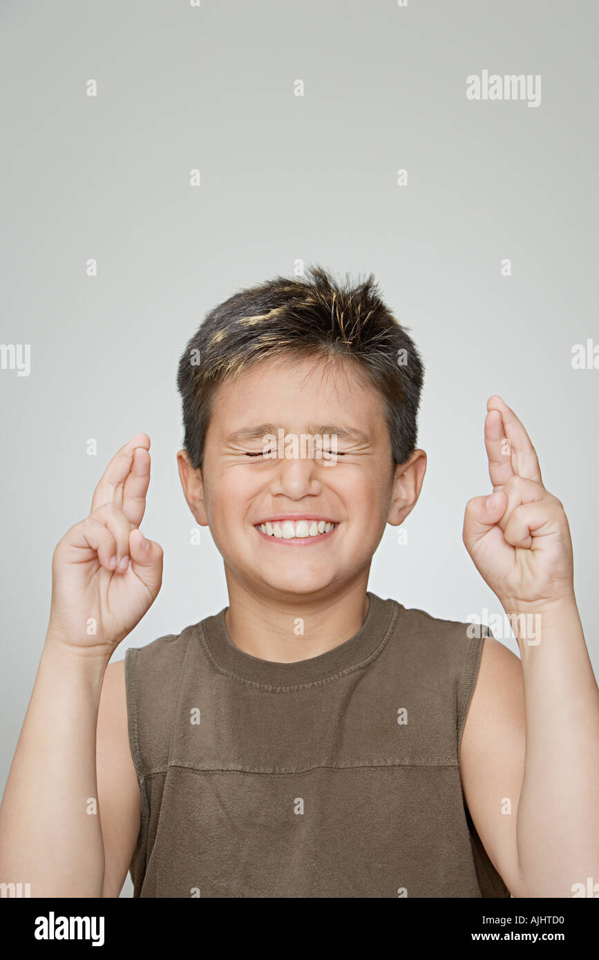 Boy with fingers crossed Stock Photo Alamy