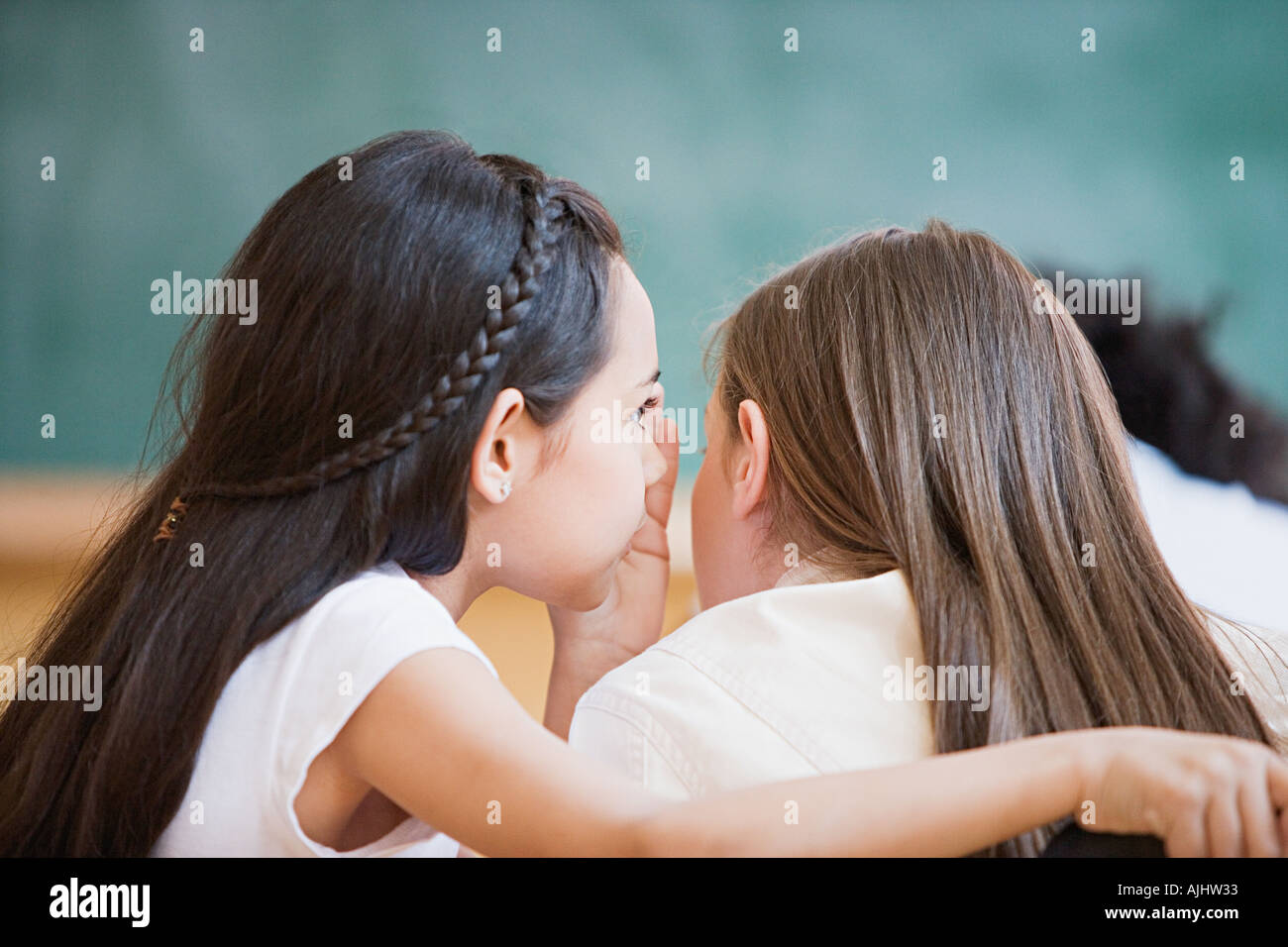 Girls whispering in class Stock Photo - Alamy
