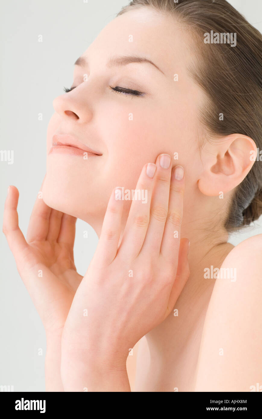 Young woman touching her cheeks Stock Photo