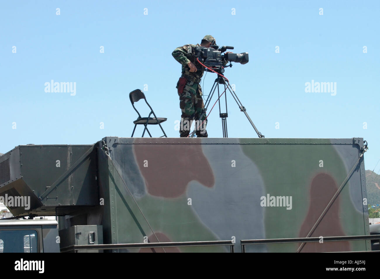 A soldier standing on top of a military command and control vehicle