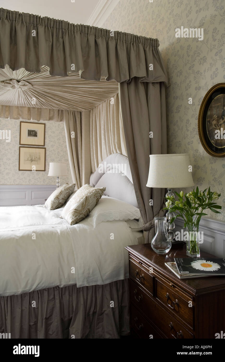 Fourposter bed with pelmet and curtain in bedroom with floral patterned wallpaper in 17th century Irish castle Stock Photo