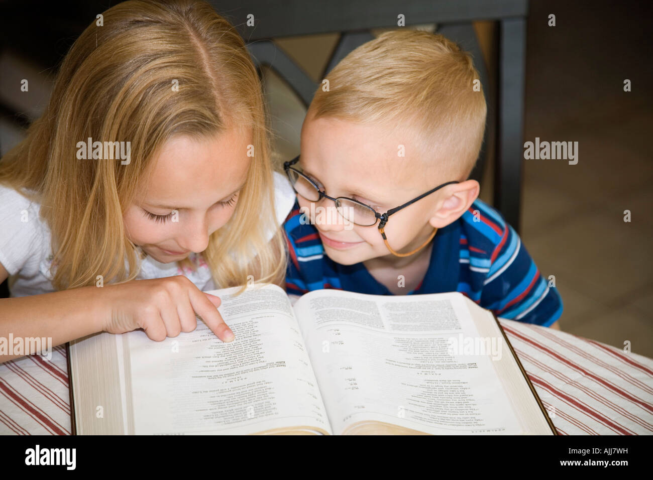 Boy and girl reading the Bible together Stock Photo