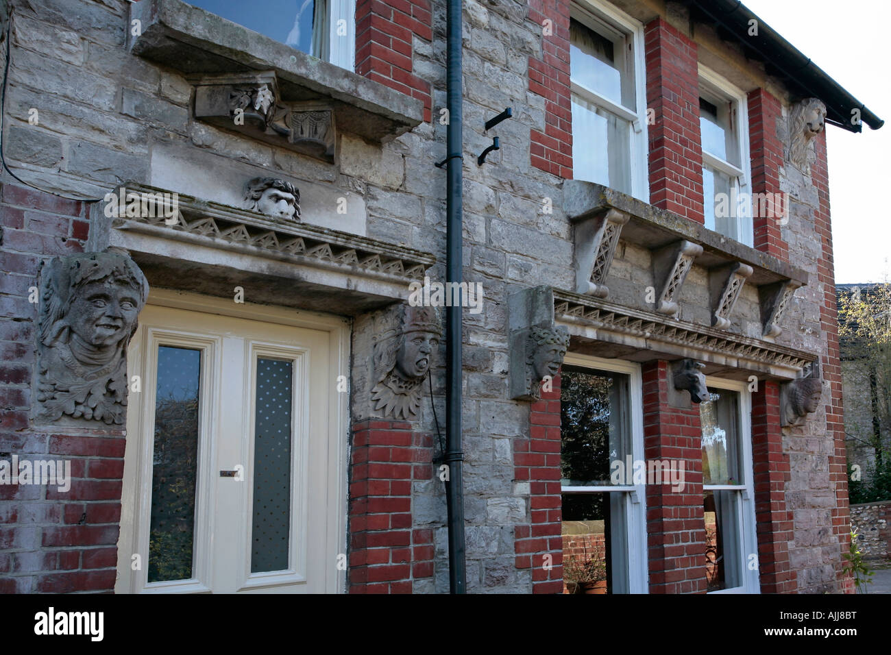House decorated with bizarre carved heads. Location Bury village, West