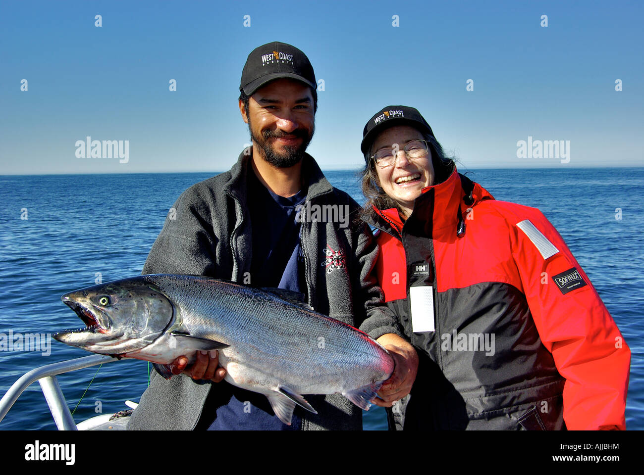 A happy angler with her trophy Kyuquot Sound chinook salmon held by her guide. Stock Photo