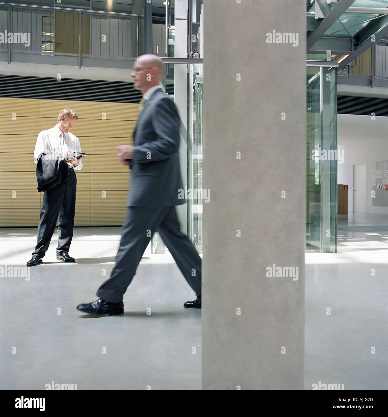 Businessmen in office lobby Stock Photo - Alamy
