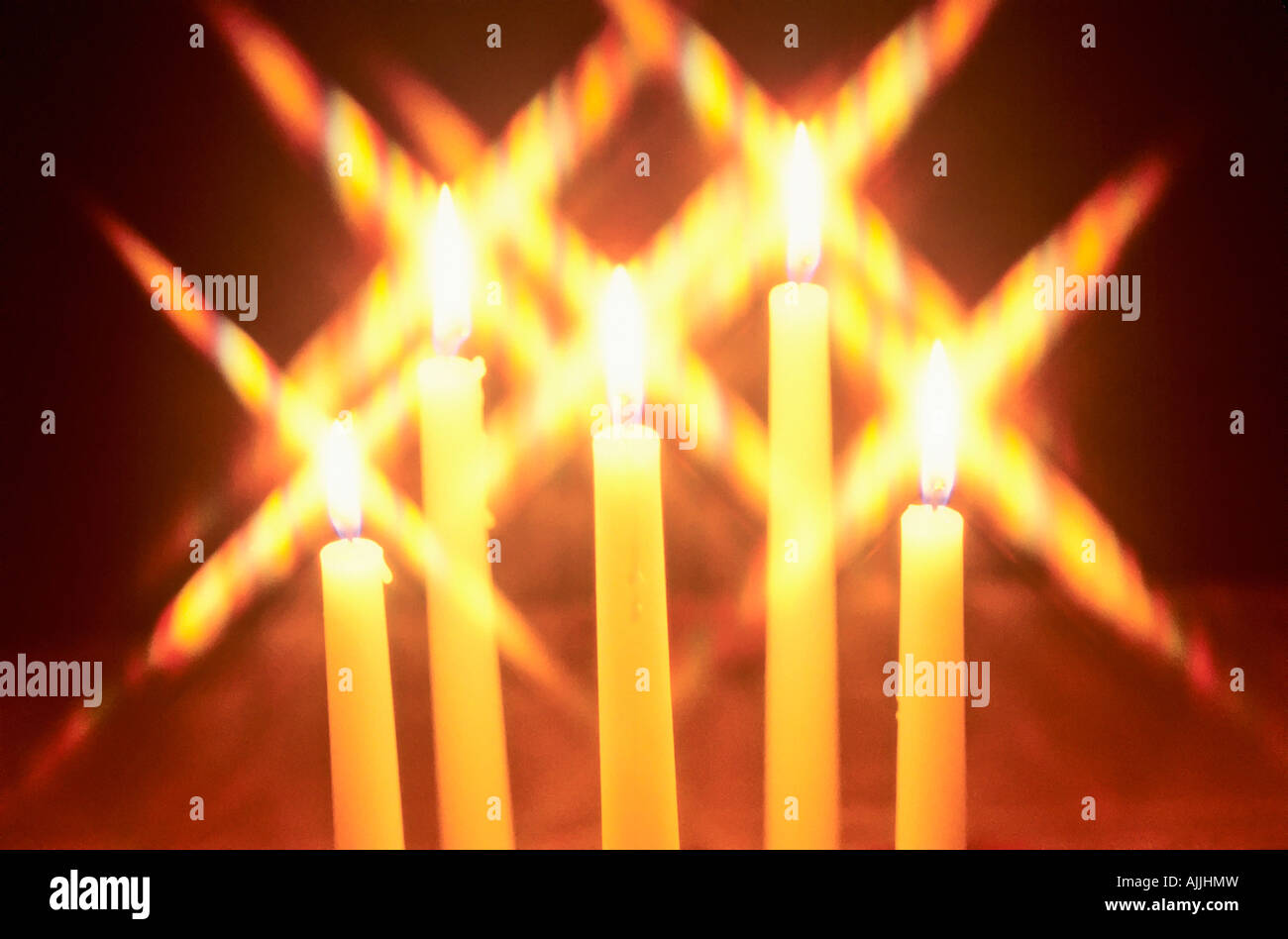 Candles lit for the Christmas holiday with star patterns in the flames