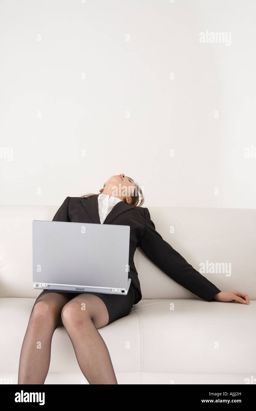 Young woman sitting on sofa with laptop Stock Photo - Alamy