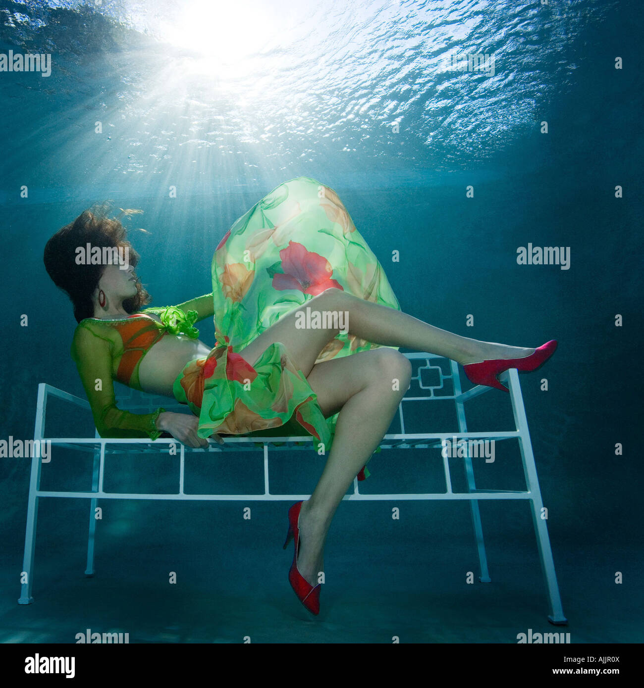 Woman in fashion outfit underwater in pool Stock Photo