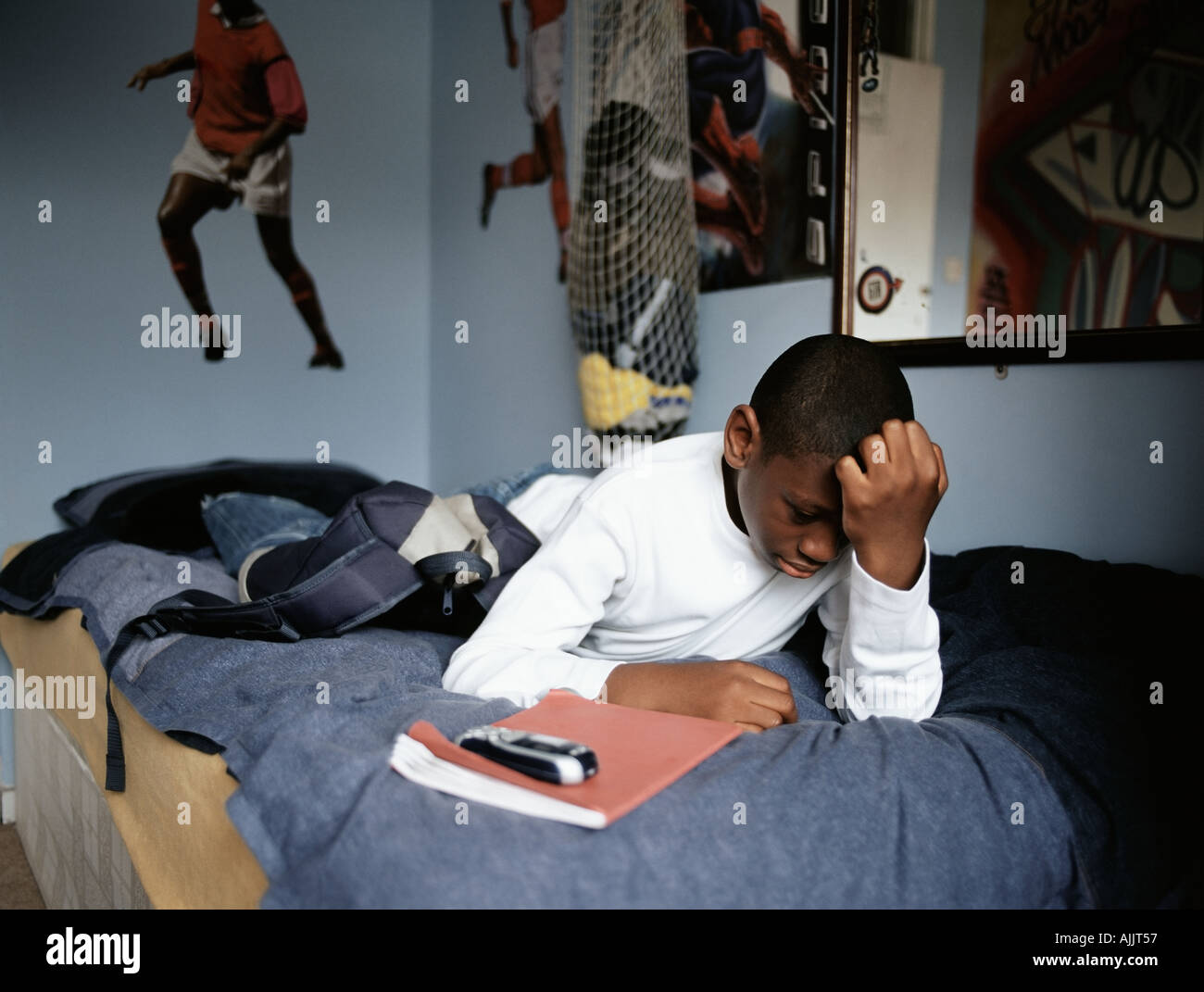 Worried boy lying on bed Stock Photo