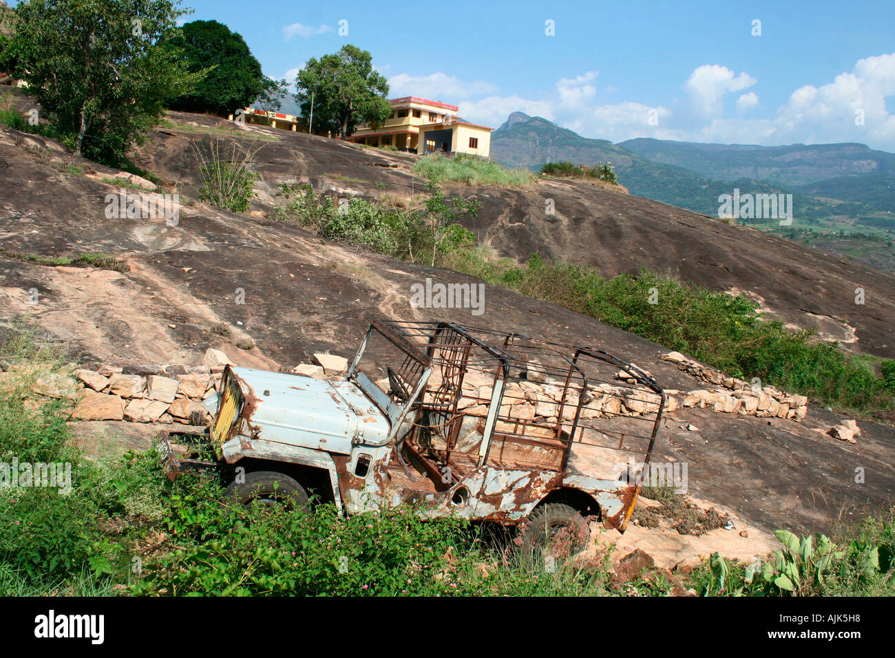 A panoramic view of a rocky landscape with an abandoned vehicle as the prime focus, Marayoor, Kerala, India Stock Photo