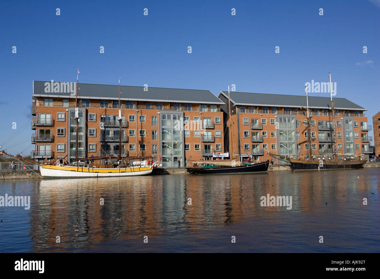 Tall ships moored by newly built flats development Gloucester Docks