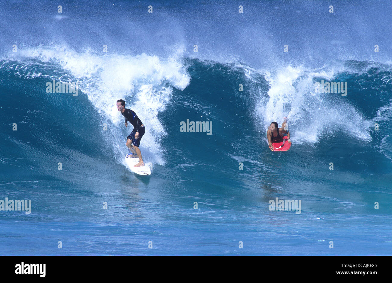 A surfer and a body boarder ride the same waves in Maui Hawaiian Islands Stock Photo