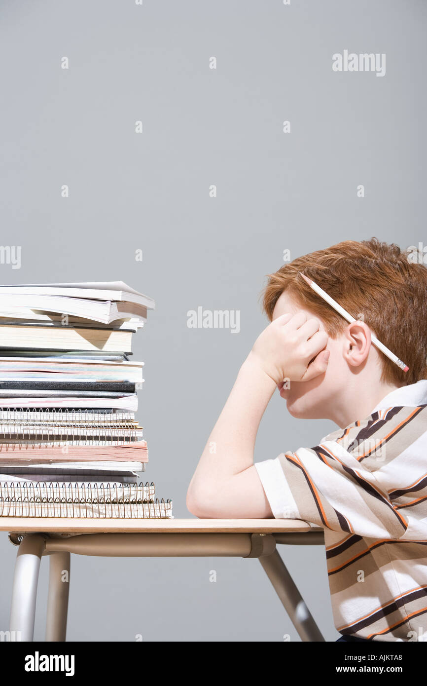 Boy with a pile of school books Stock Photo - Alamy
