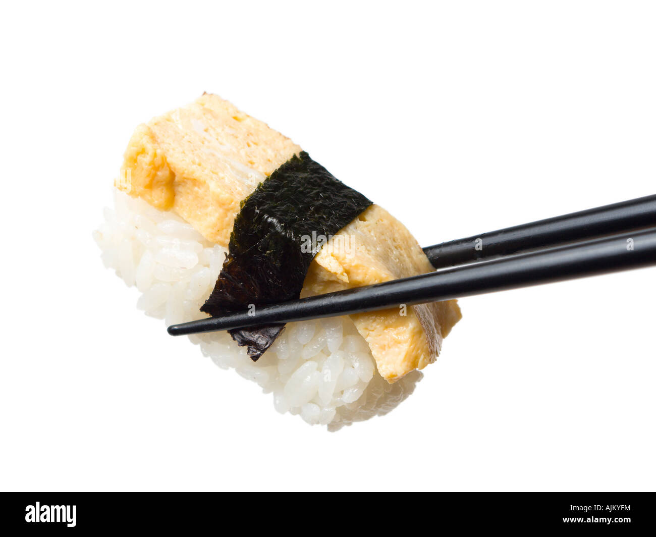 a piece of nigiri sushi with scrambled egg held between chopsticks isolated white background Stock Photo