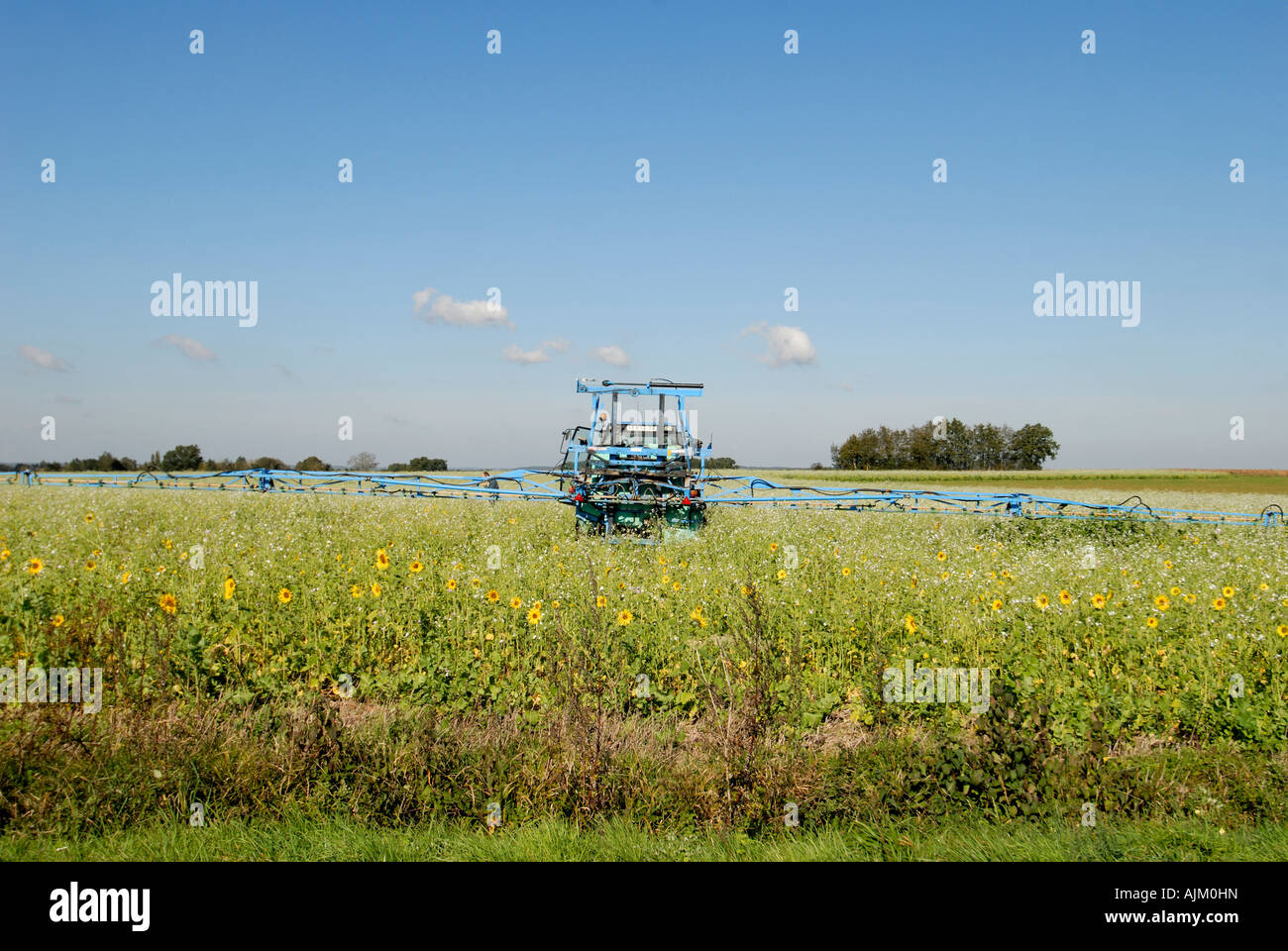 Tractor with crop sprayer boom extended, Vienne, France. Stock Photo