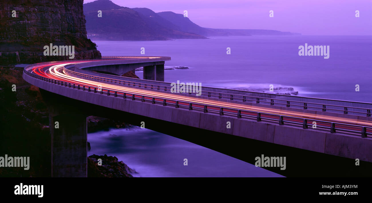 Light trails blaze across Seacliff Bridge at evening twilight, Wollongong NSW Australia Stock Photo