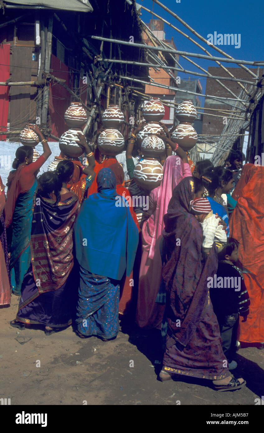 Indian women colorful dressed in sari and with presents on their head for a wedding in India Rajastan Stock Photo